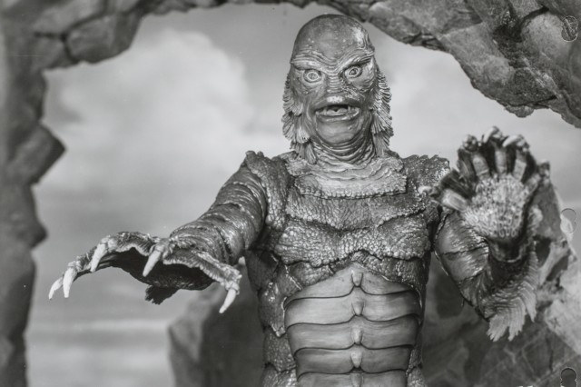 The Creature from the Black Lagoon, a fish like man, reached with his outstretched webbed fingers.