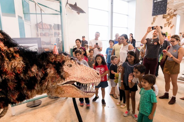 Image of dinosaur puppet with museum visitors