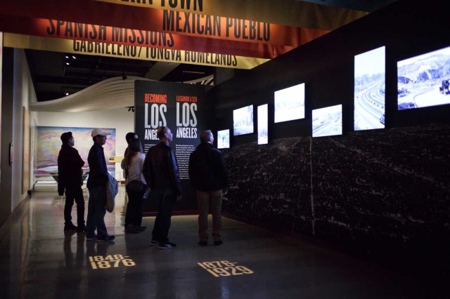 Entrance to Becoming Los Angeles Exhibition filled with historic images and colorful banners