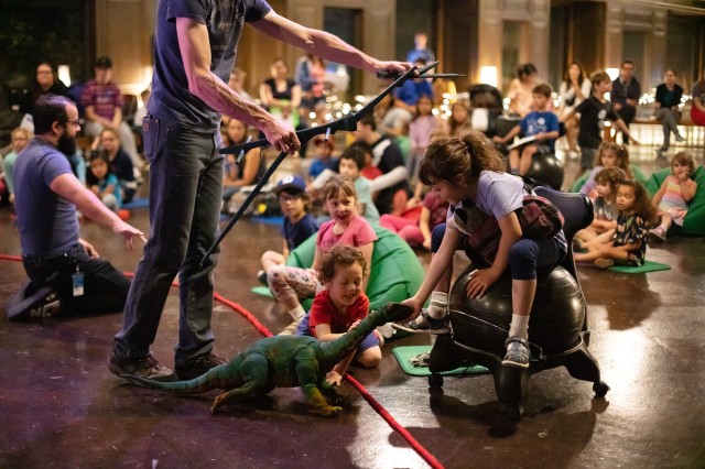 Kids with Dinosaur puppet during Dinosaur Encounters show