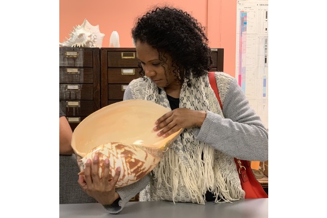 Rihighna&#039;s mother Erlinda gets a close up look at a large shell that is part of the Malacology collection.