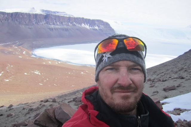 Nathan Smith standing near excavation site in Antarctica. 