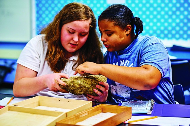 two girls examining a fossil