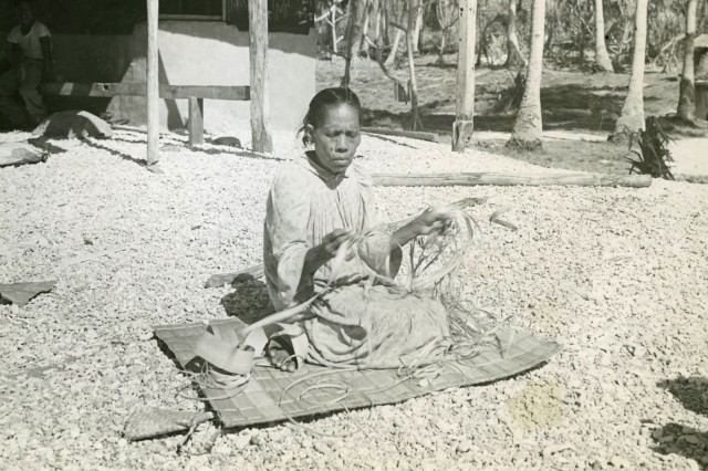 Woman sitting on woven mat
