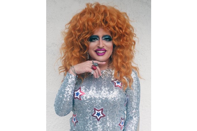 Drag queen with silver sequin dress and curly red hair