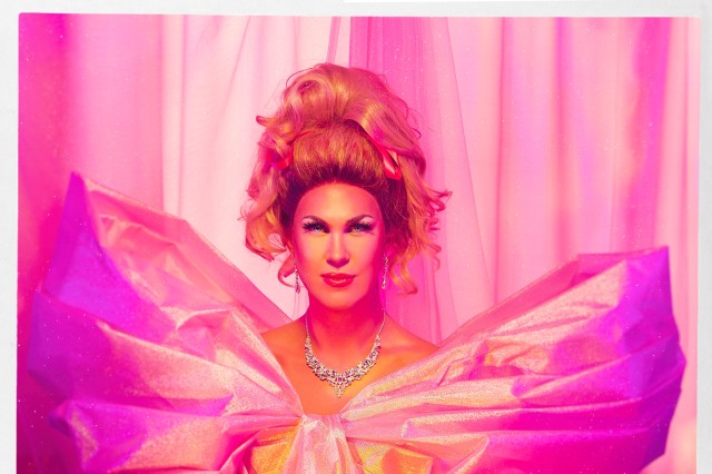 Drag queen in pink dress with puffy sleeves and a diamond necklace