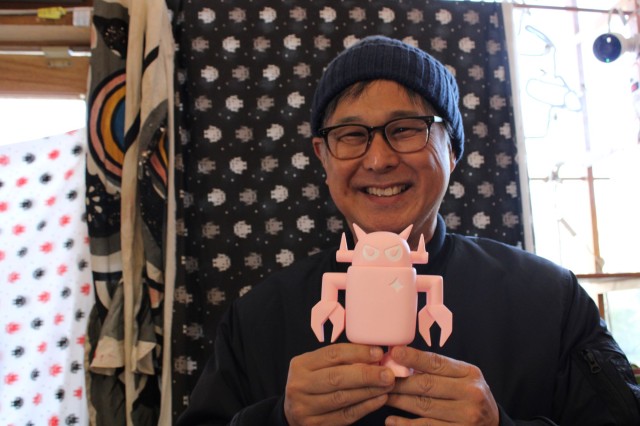 Man holding pink robot figurine
