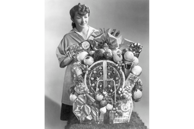 Mrs. Julliette Page poses with a very large and elaborate gift basket.