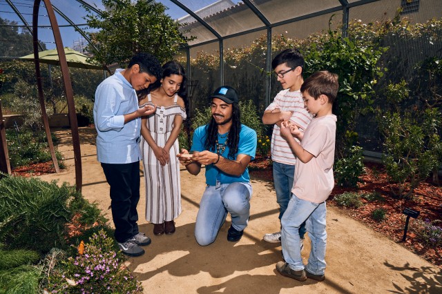 A Museum Educator interacting with visitors in the Butterfly Pavilion