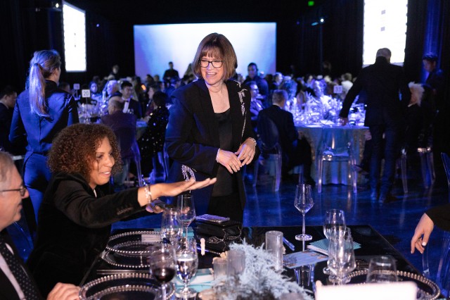 Dr. Lori Bettinson-Varga talking to a guest at a table at Dino Ball 2023