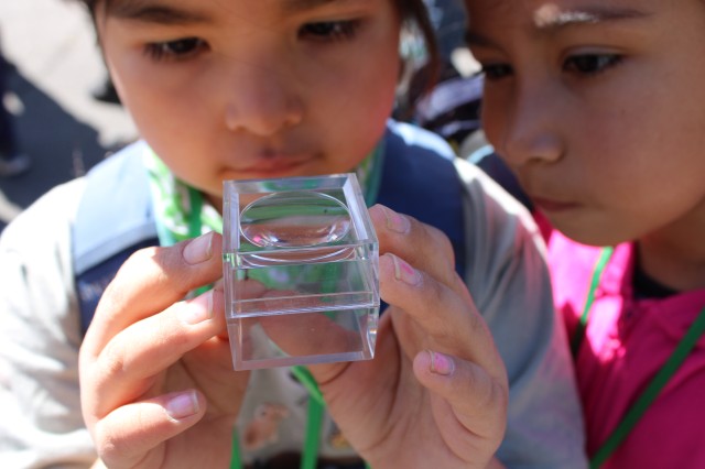 Children looking at a specimen in a magnifiying case