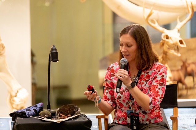 women holding bird specimen speaks in microphone