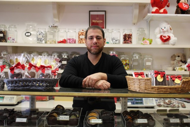 Man standing in front of chocolate counter 