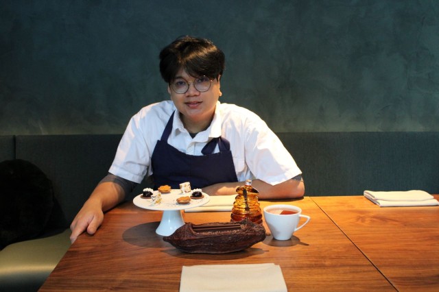 Chef sitting at table with small desserts in front 