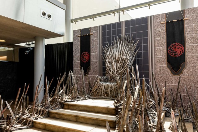 Silver replica swords on either side of steps leading to a throne made up of silver replica swords