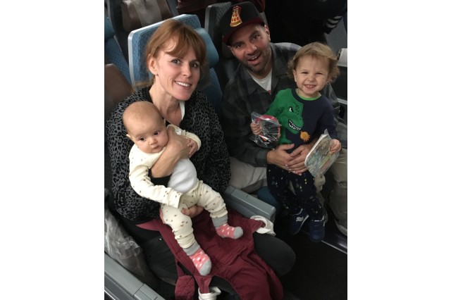 Husband and wife on a plane with a toddler-age son in the father&#039;s lap and an infant daughter in the mother&#039;s lap. 