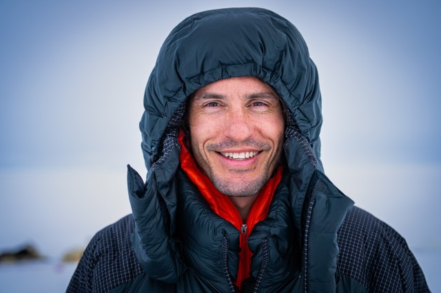 Nate Dappen wearing a navy hooded jacket against a blurry blue sky