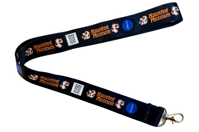 Haunted Museum in orange letters between cartoon ghosts on a black strap