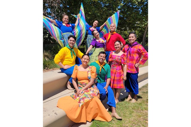 Group of dancers in bright clothing gathered on outdoor steps