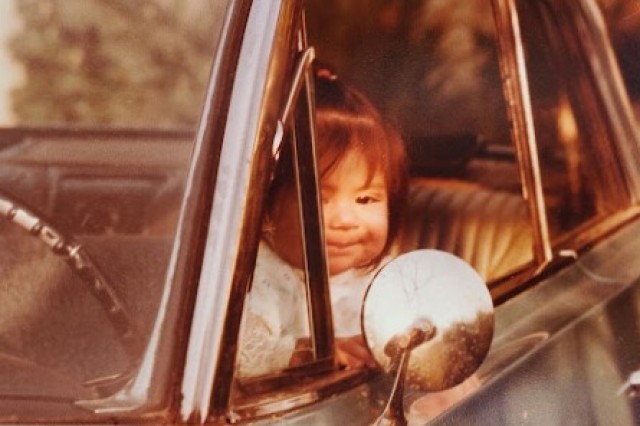 Baby Sandy Avila sitting in the drivers seat of her dad&#039;s lowrider.