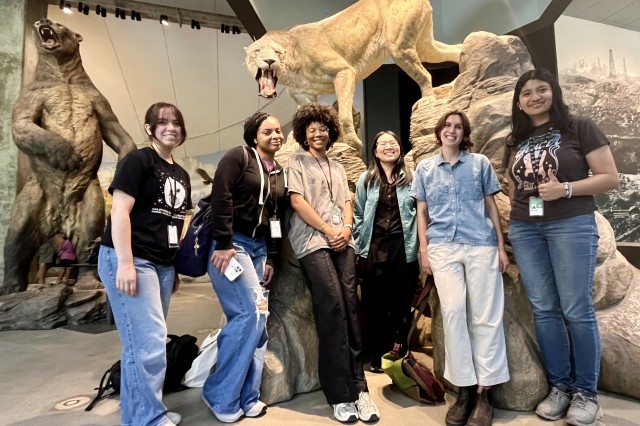 Interns gathered in front of a taxidermy mountain lion