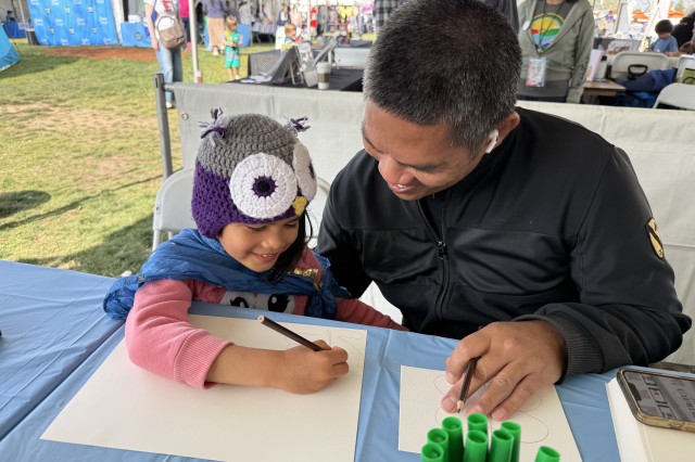 Parent and child sitting at a table drawing