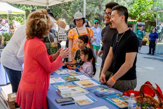 Visitors at a table with pamphlets and flyers spread out on top