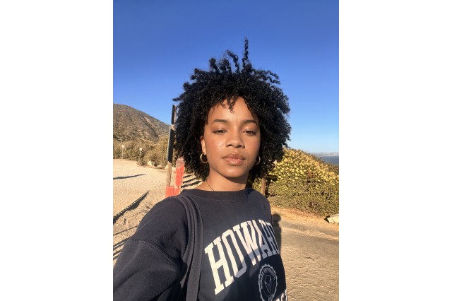Kendall Buycks wearing a black sweatshirt with Howard in white capital letters with hills and blue sky in the background