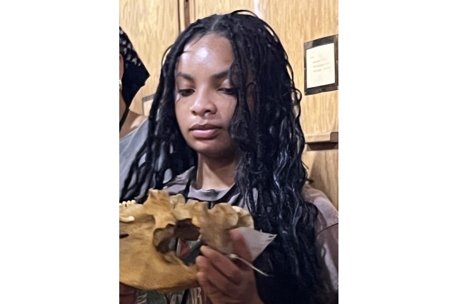 Shariah Kyle holding and looking down at a specimen