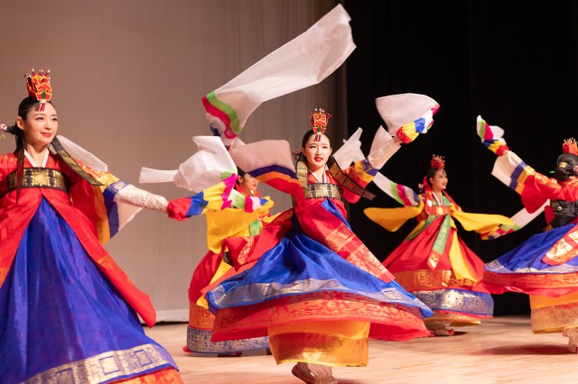 Dancers twirling on a stage and waving their long sleeves in the air 