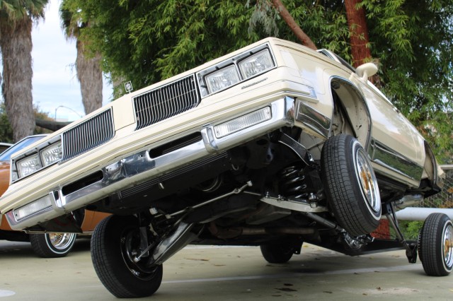 White lowrider car up on hydraulics.