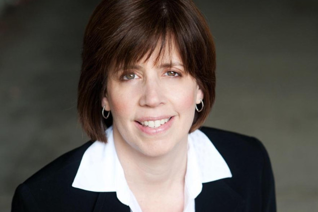 Head and shoulders portrait of Dete Meserve, wearing a white collared shirt under a black blazer