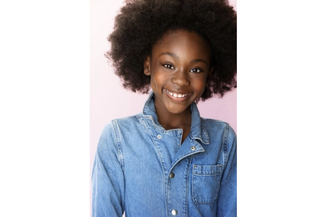 Tandi Akwen Fomukong smiling and wearing a blue denim button down shirt