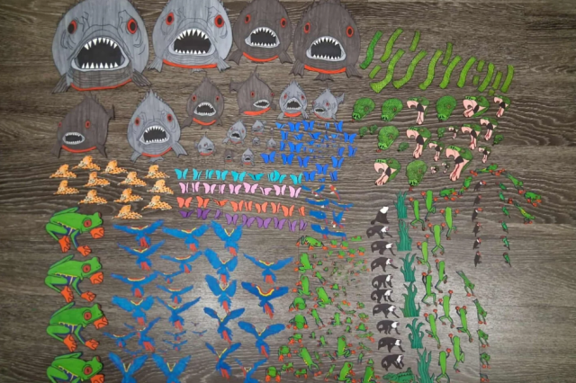 Cut-out shark heads, frogs, and other creatures on a table top