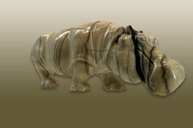 Hippo carved from calcite, light brown stone with black streaks.