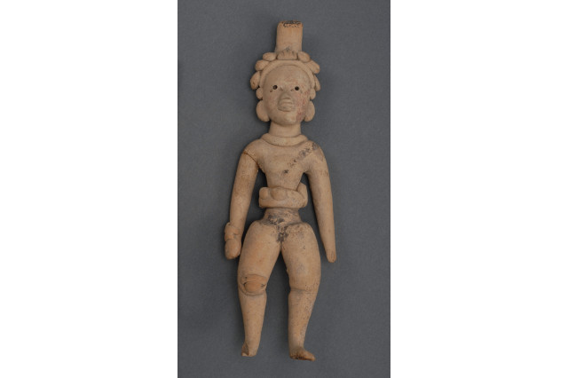 Mesoamerican ceramic figurine of a ball player wearing a yolk and headdress.