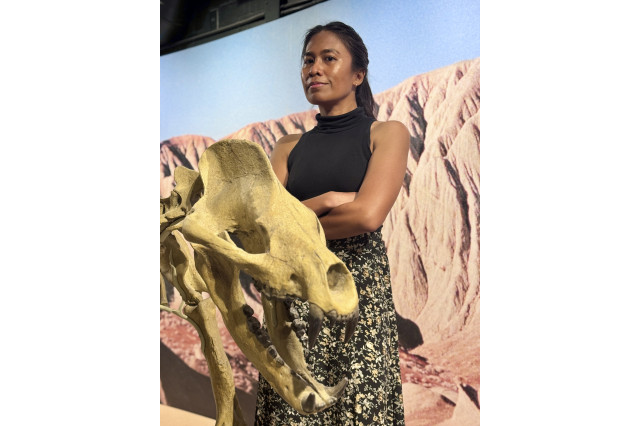 Photo of Dr. Balisi next to a prehistoric animal