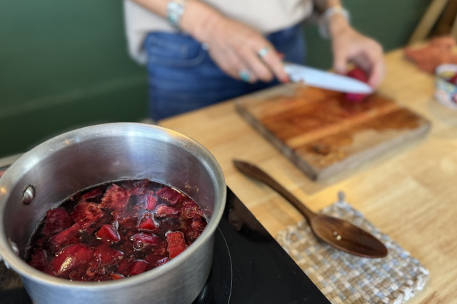 Chopped cactus fruit boiling in a metal sauce pan.