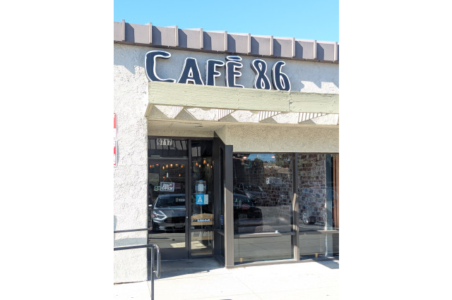 Cafe store front with the sign "Cafe 86" above the glass entryway.