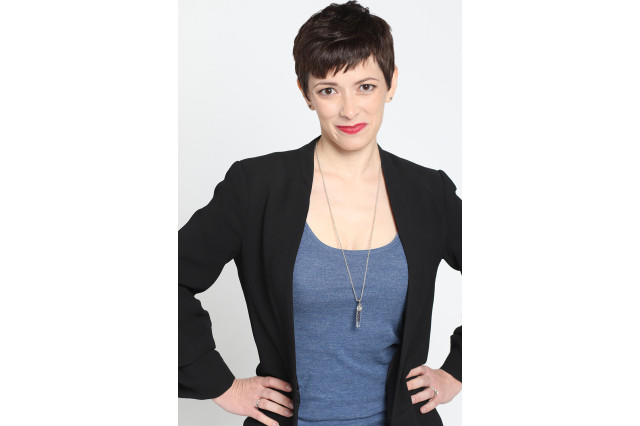 Barbra Dillon, wearing a black blazer, with hands on hips