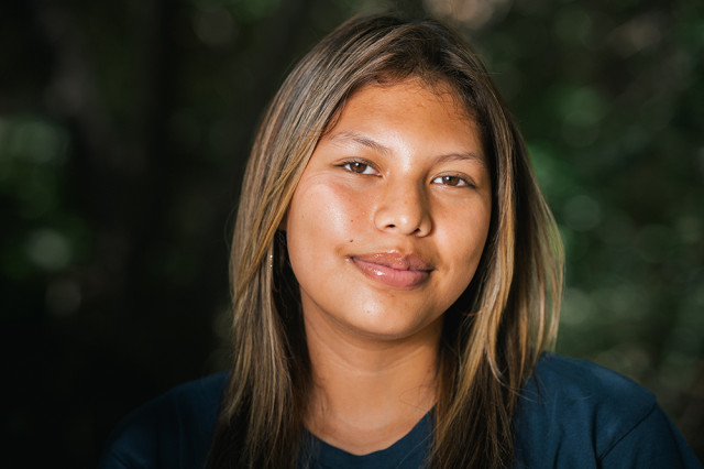 Head and shoulders portrait of Celeste Cruz, against a leafy green background