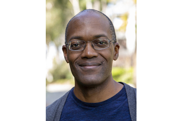 Head and shoulders portrait of Clifford Johnson, wearing glasses and smiling