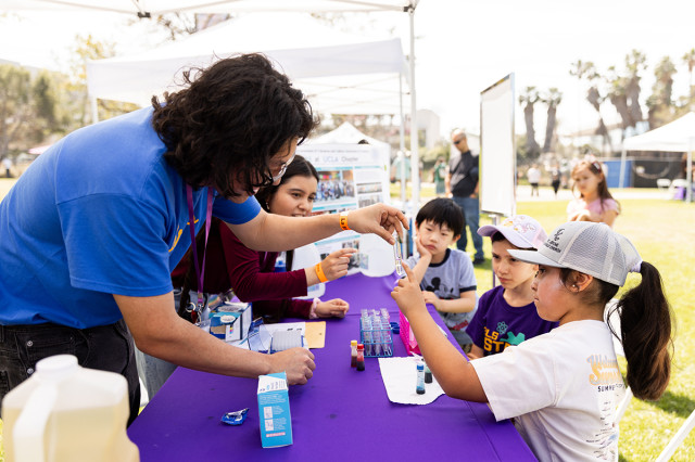Educator showing a vial of liquid to children across a table