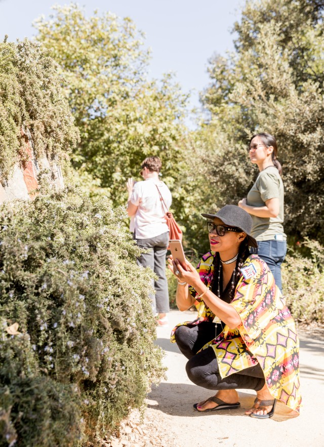 woman in nature gardens taking a picture superproject community science