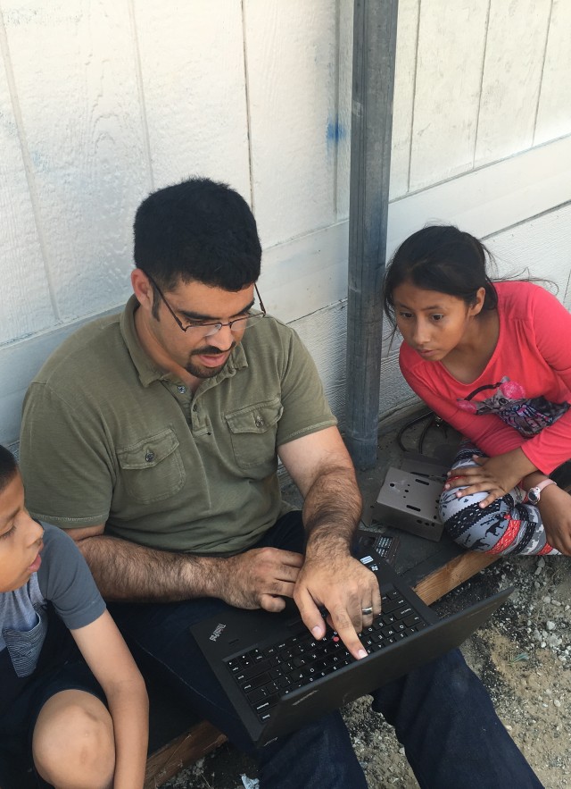 Miguel and students look at camera trap photos community science wildlife