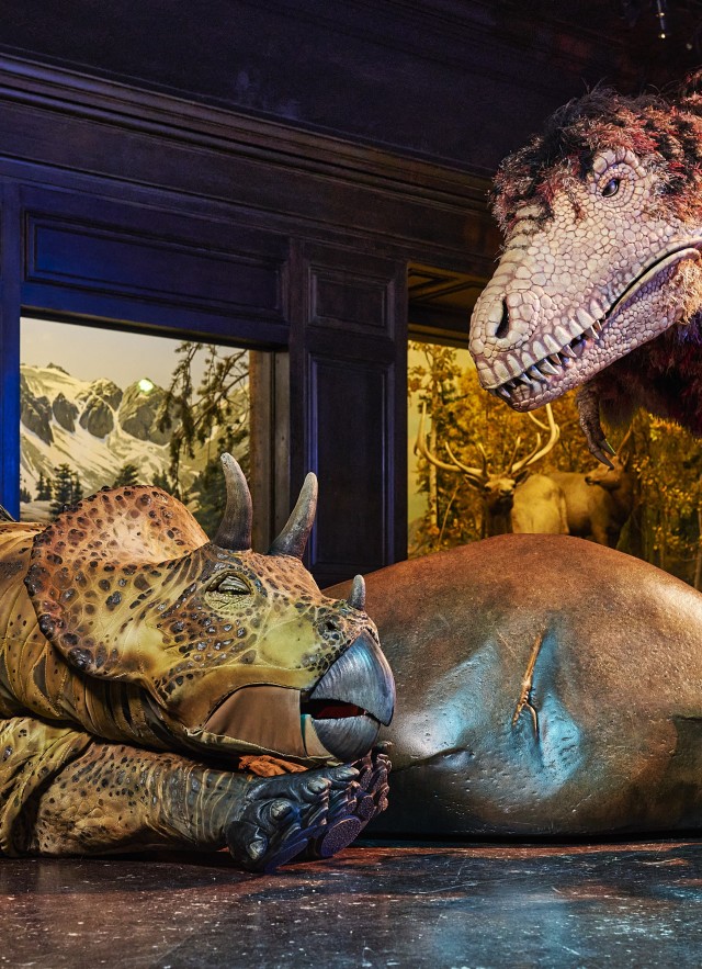 Life size realistic dinosaur puppets depicted during dinosaur encounters performance.