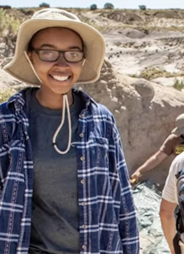 Adriana Stephenson wearing a hat and glasses in a rocky terrain