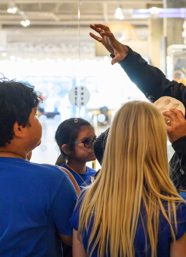 Miguel interpreting with a mountain lion track print at the P-22 exhibit.