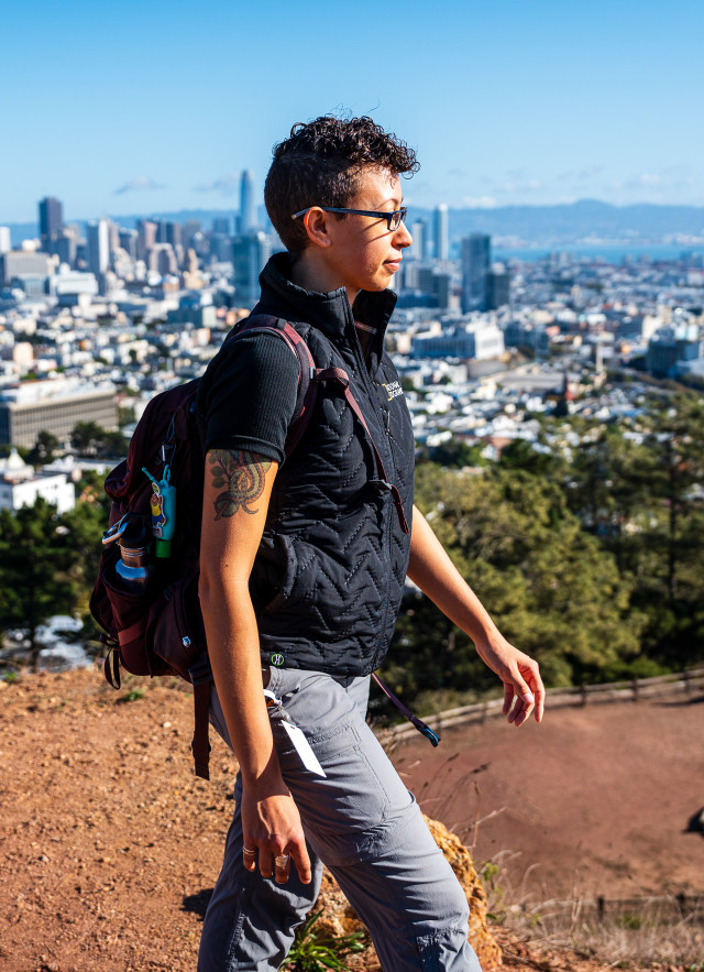 A cool-looking person wearing a backpack walks above the city skyline