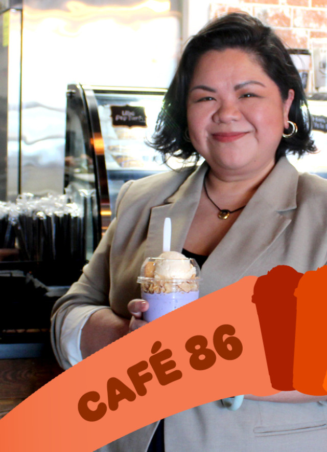 Filipino woman holding out a colorful boba drink in front of the counter at her cafe.